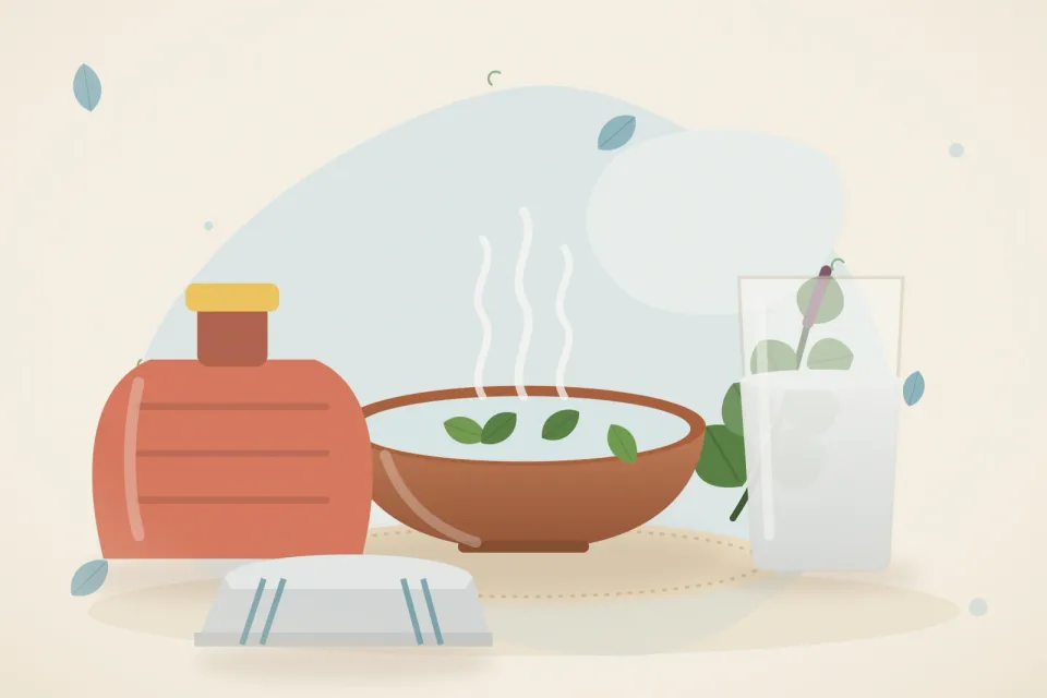 A steaming bowl with tulsi leaves, a hot water bag, a folded towel and a glass of warm water on an icy-blue background